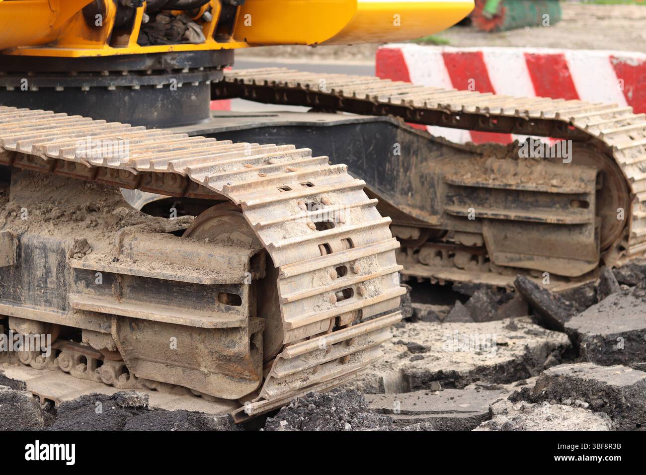 Primo piano del cingolo dell'escavatore. Primo piano di una parte dell'escavatore da cantiere, veicolo cingolato. Lavori di riparazione in città. Attrezzatura speciale. Attrezzature Foto Stock