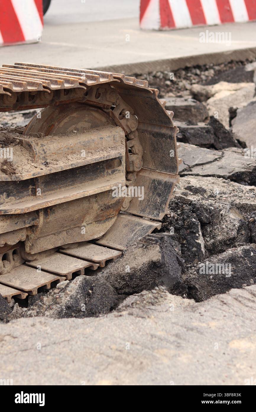 Primo piano del cingolo dell'escavatore. Primo piano di una parte dell'escavatore da cantiere, veicolo cingolato. Lavori di riparazione in città. Attrezzatura speciale. Attrezzature Foto Stock