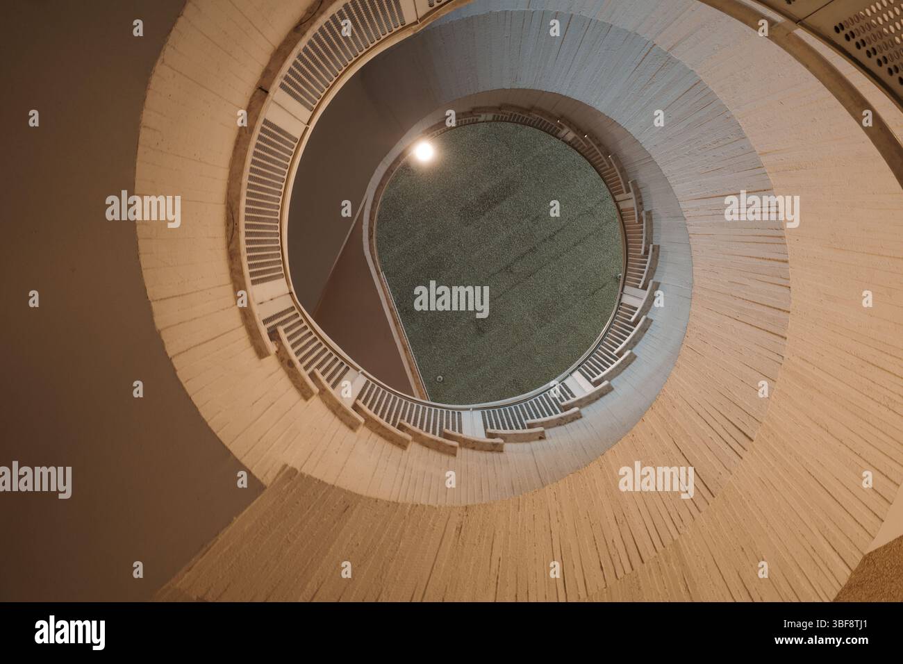Vista dall'alto di una scala a chiocciola che forma un modello circolare con dettagli architettonici e simmetria. Foto Stock