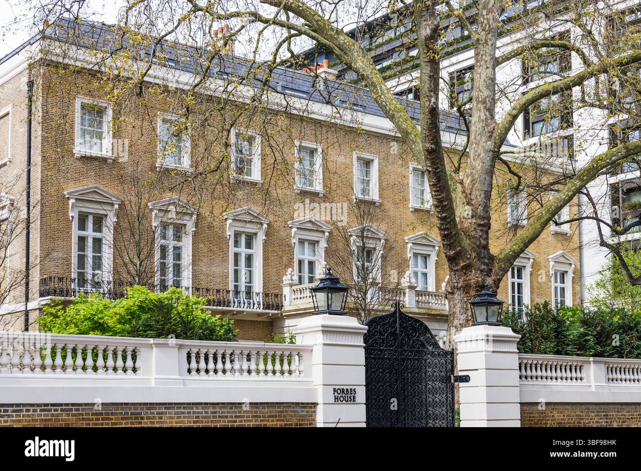 Classica casa di mattoni britannici con Iron Gate e White Trim in un quartiere di lusso Foto Stock