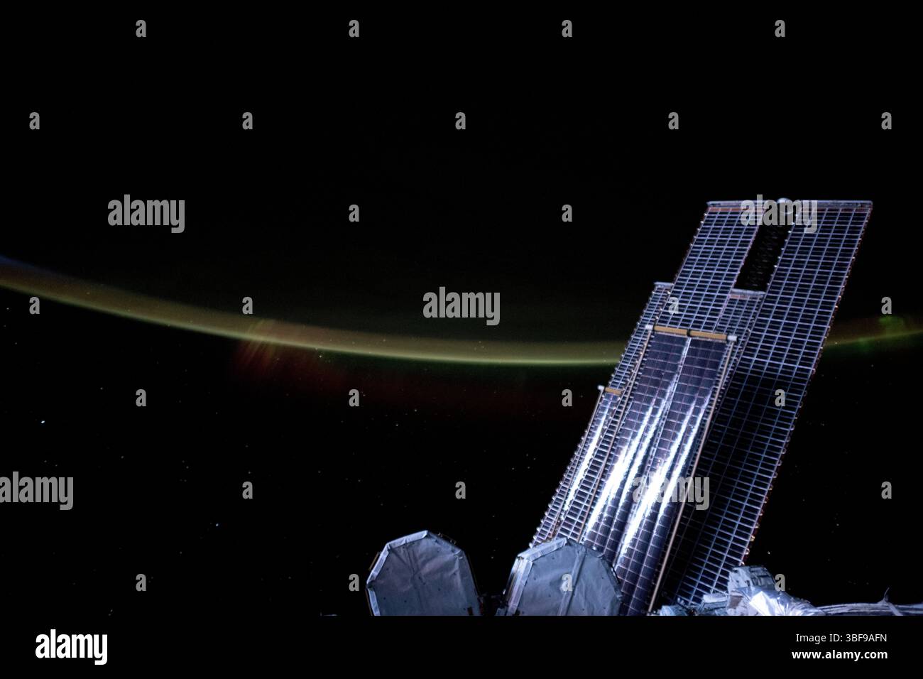 Il chiaro di luna proietta una luce argentata su una serie di pannelli solari principali della stazione spaziale Internazionale e di pannelli solari che si diffondono e coronati dal bagliore atmosferico terrestre e da un'aurora selvaggia mentre orbitava a 272 miglia sopra l'Oceano Indiano meridionale alle 20:06 ora locale. Una versione ottimizzata di un'immagine originale della NASA - credito: NASA Foto Stock