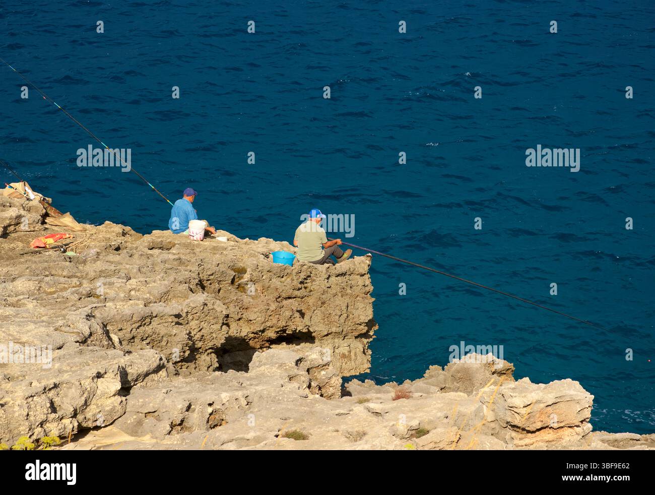 Pescatori, pesca da scogli con canne da pesca alla spiaggia di Funnov˜jere, nel comune di Corsano, nella parte sud-occidentale del Salento, in provincia di Lecce, Puglia, Italia. Questo angolo nascosto si affaccia sul mare Adriatico, caratterizzato da scogliere e rocce a picco sul mare, Foto Stock