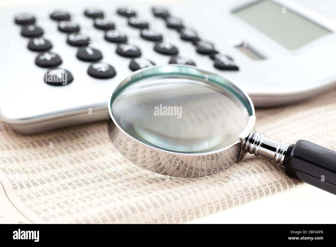 Giornale finanziario con calcolatrice e lente di ingrandimento. Primo piano. IMPUGNATURA piccola Foto Stock