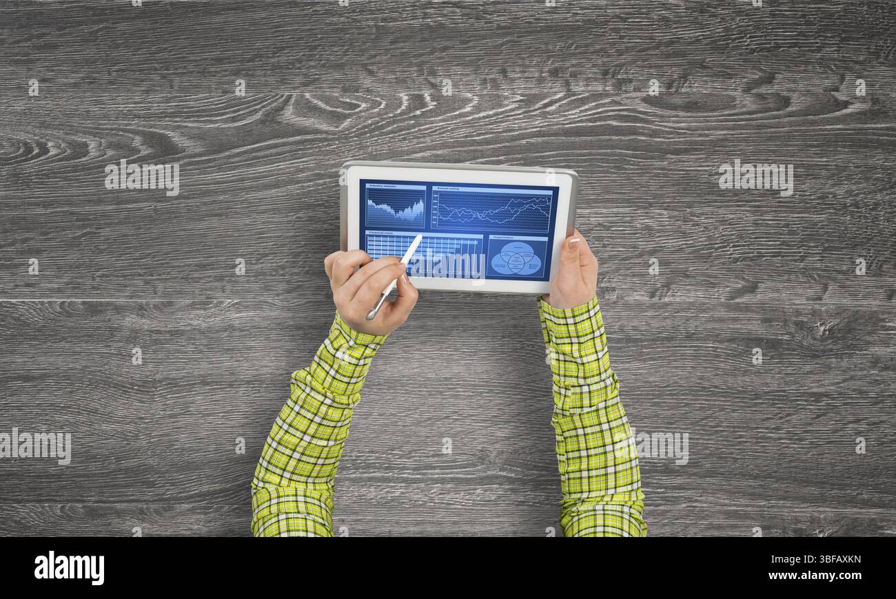 Vista superiore della ragazza mani con tablet pc con diagrammi e grafici sullo schermo Foto Stock