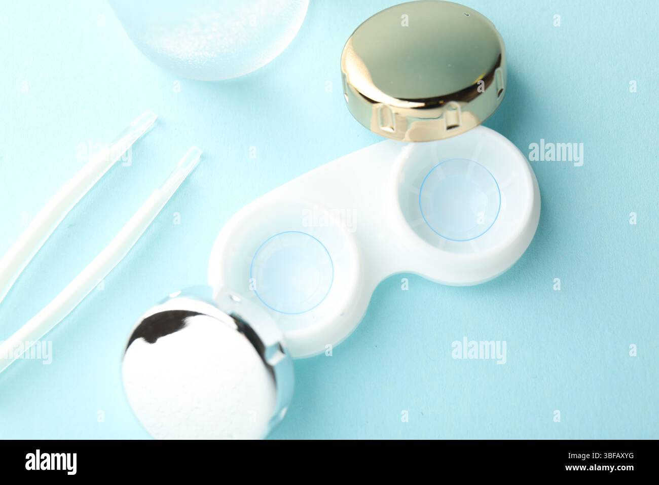 Lenti a contatto in custodia e pinzette su sfondo turchese chiaro, piatto Foto Stock