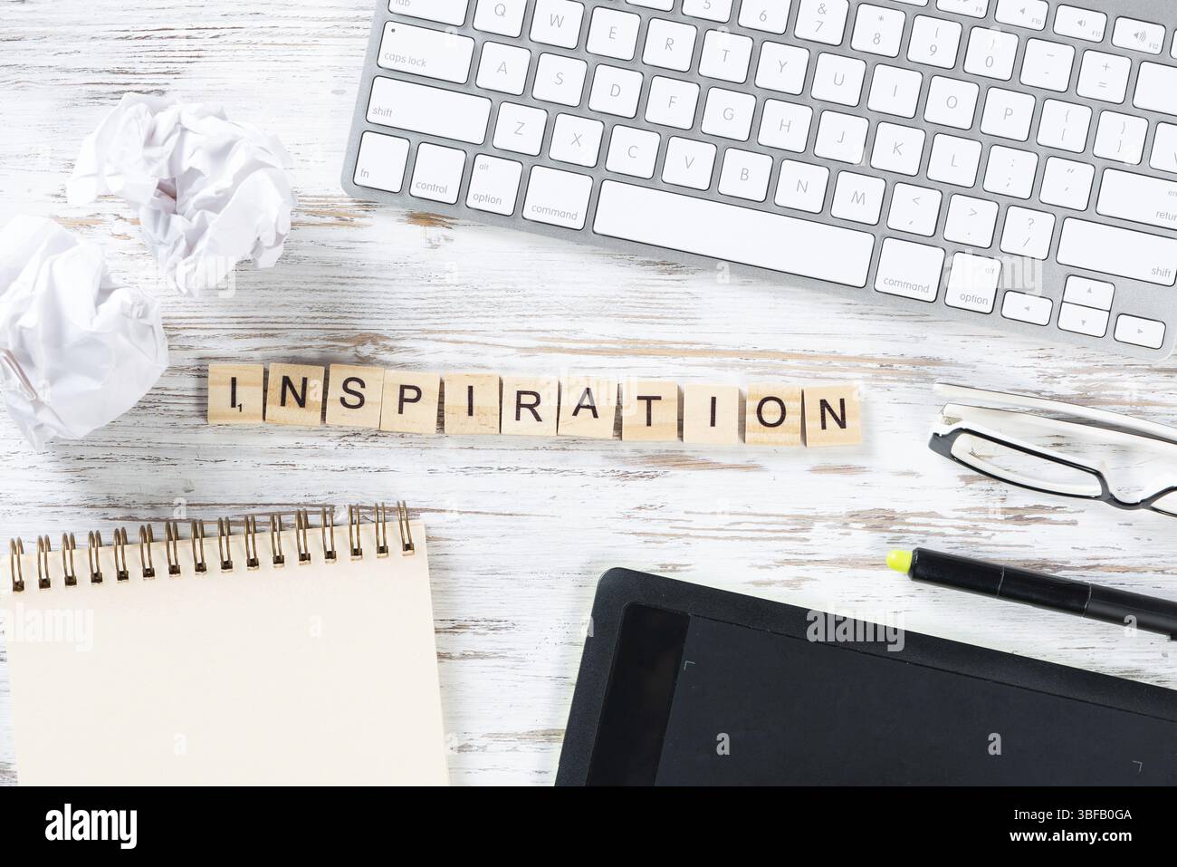 Concetto di ispirazione e motivazione con lettere sui cubi. Durata residua dello spazio di lavoro con materiali di consumo. Scrivania piatta in legno con tablet e spirale Foto Stock
