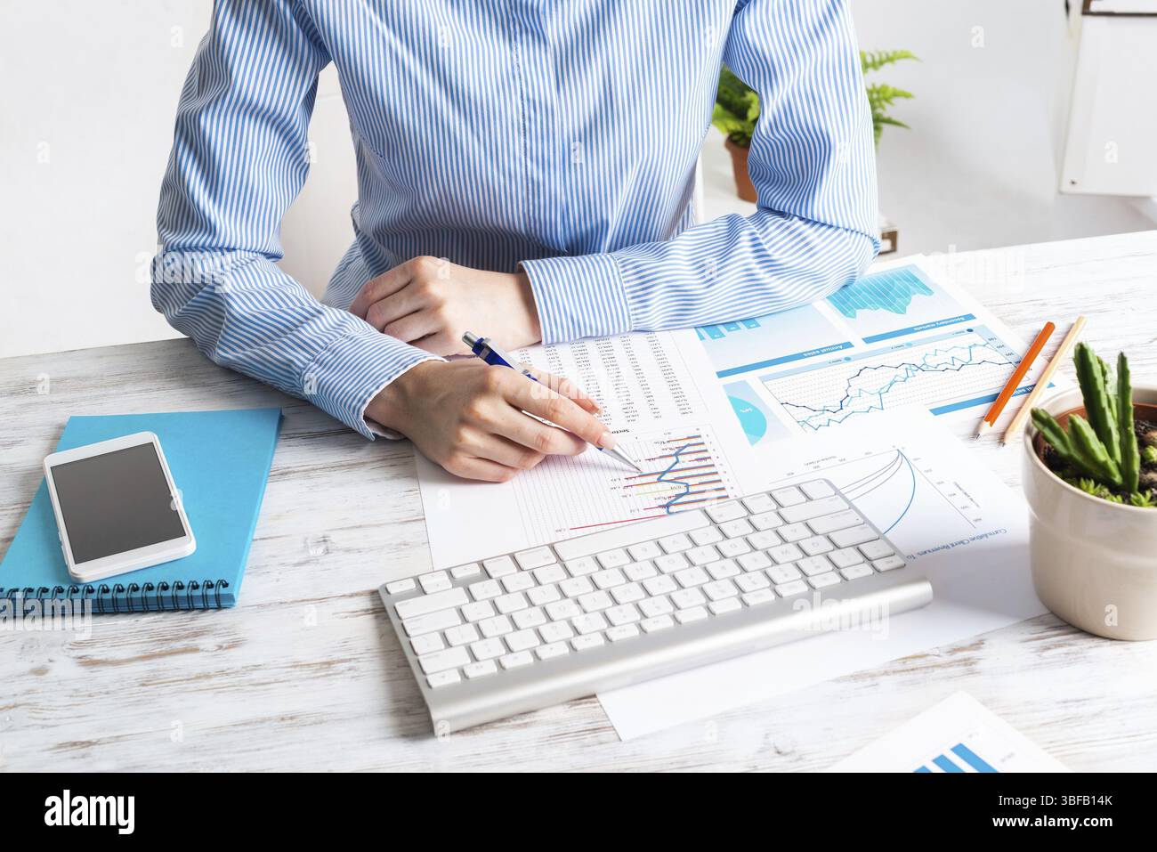 Consulente aziendale seduto alla scrivania e analizzato il rapporto finanziario. Pianificazione strategica e investimenti. Ufficio aziendale con analista presso Wooden Foto Stock