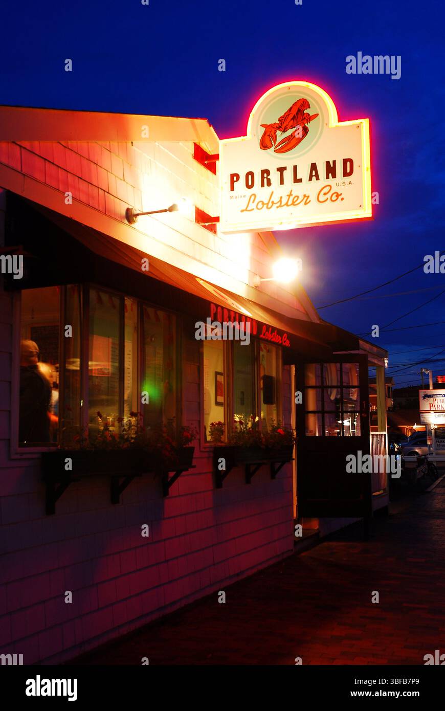 Una baracca di aragosta sul lungomare di Portland, Maine, si illumina contro un cielo crepuscolo Foto Stock