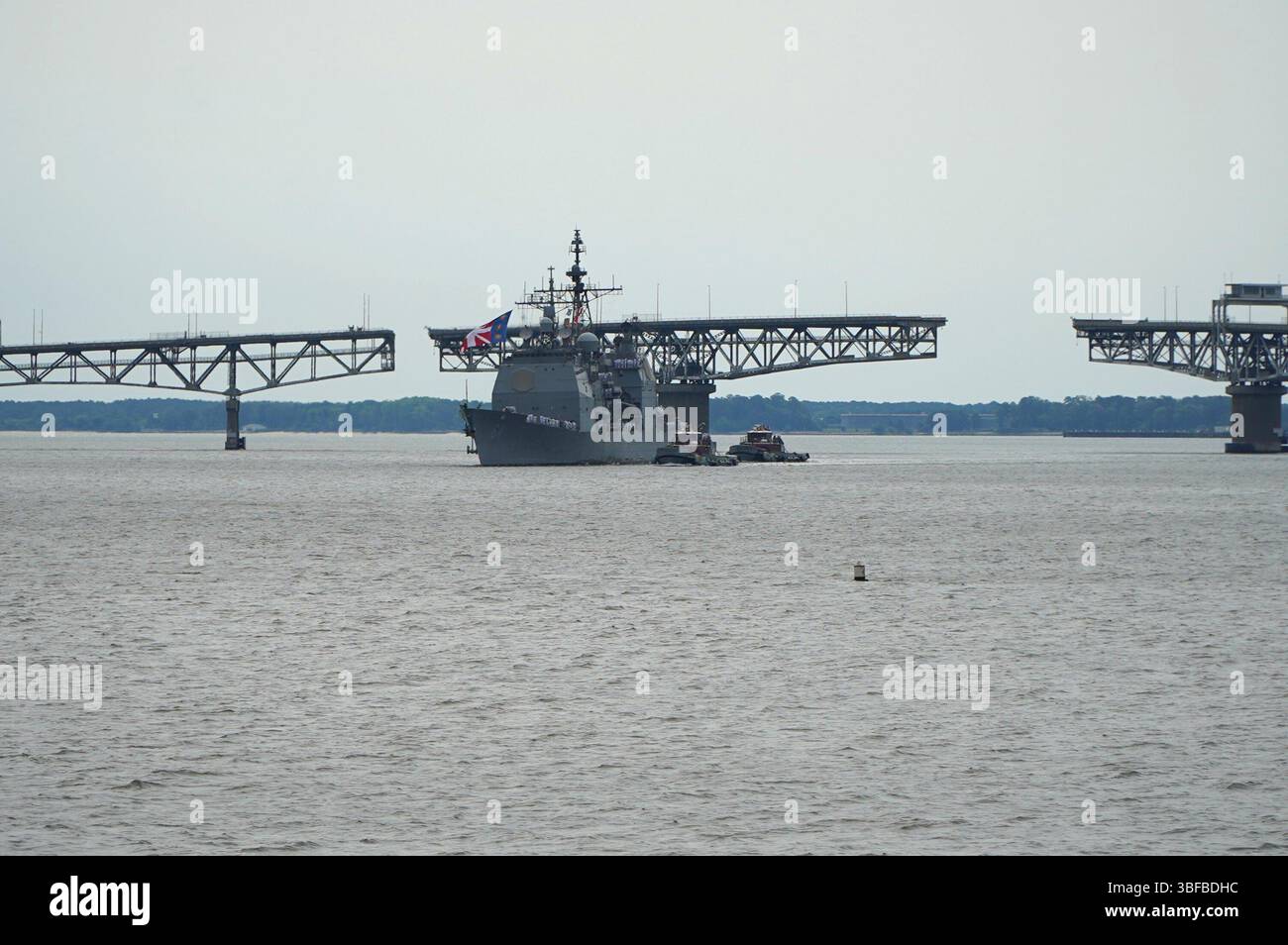 Yorktown, Virginia (31 maggio 2025) l'incrociatore missilistico guidato classe Ticonderoga USS Gettysburg (CG 64) transita sul fiume York con il Coleman Bridge sullo sfondo mentre l'incrociatore si prepara ad ormeggiare al molo delle armi R-3 a bordo della Naval Weapons Station Yorktown. L'incrociatore, portato a Norfolk, Virginia, e il suo equipaggio stavano tornando a Yorktown per scaricare le armi dopo un dispiegamento di quasi 9 mesi nelle aree di responsabilità del comando centrale e europeo degli Stati Uniti. Decine di familiari e persone a carico hanno atteso con ansia l’arrivo dell’incrociatore al molo. (Foto della Marina degli Stati Uniti di Max Lonzanida/R. Foto Stock