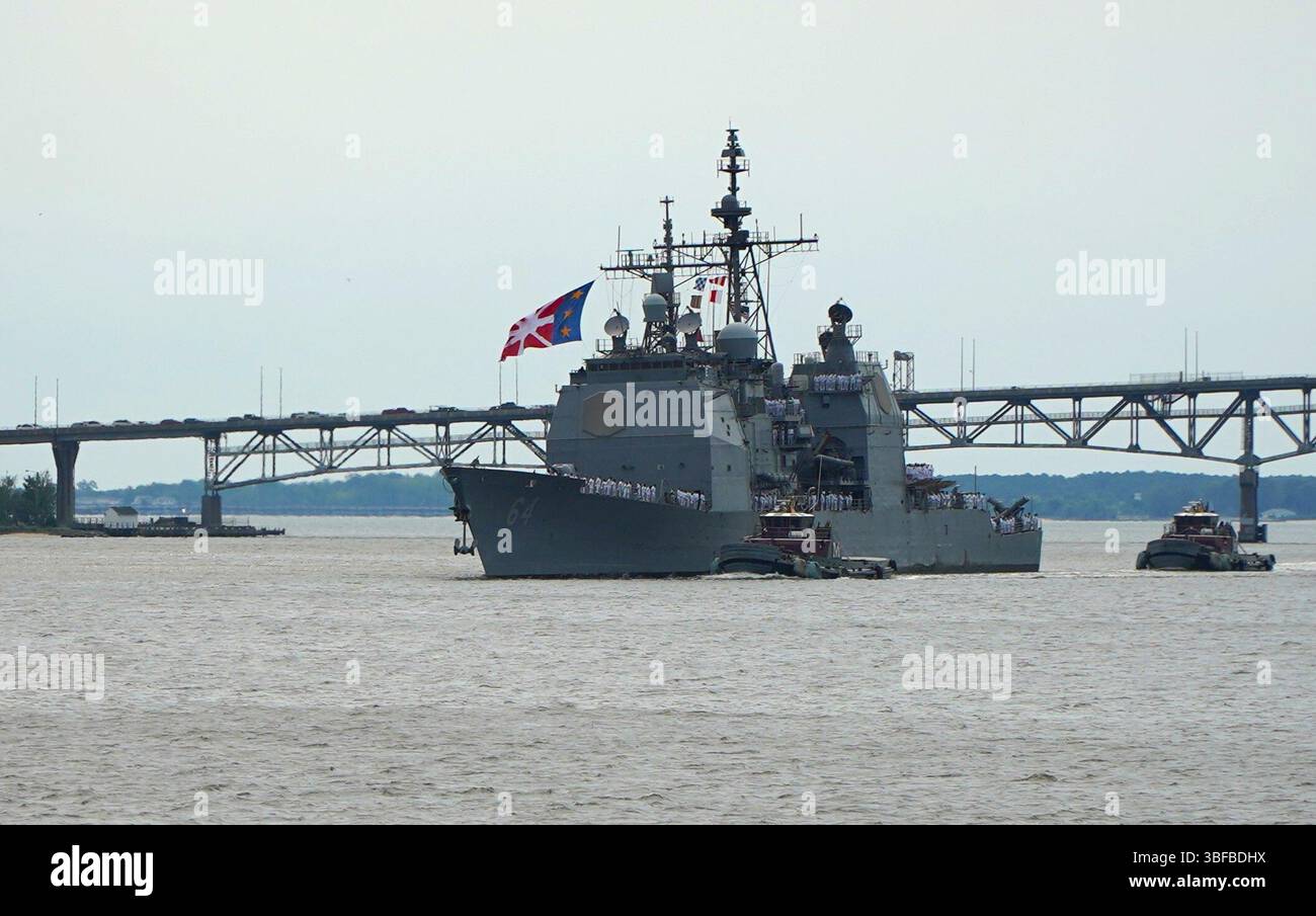 Yorktown, Virginia (31 maggio 2025) l'incrociatore missilistico guidato classe Ticonderoga USS Gettysburg (CG 64) transita sul fiume York con il Coleman Bridge sullo sfondo mentre l'incrociatore si prepara ad ormeggiare al molo delle armi R-3 a bordo della Naval Weapons Station Yorktown. L'incrociatore, portato a Norfolk, Virginia, e il suo equipaggio stavano tornando a Yorktown per scaricare le armi dopo un dispiegamento di quasi 9 mesi nelle aree di responsabilità del comando centrale e europeo degli Stati Uniti. Decine di familiari e persone a carico hanno atteso con ansia l’arrivo dell’incrociatore al molo. (Foto della Marina degli Stati Uniti di Max Lonzanida/R. Foto Stock