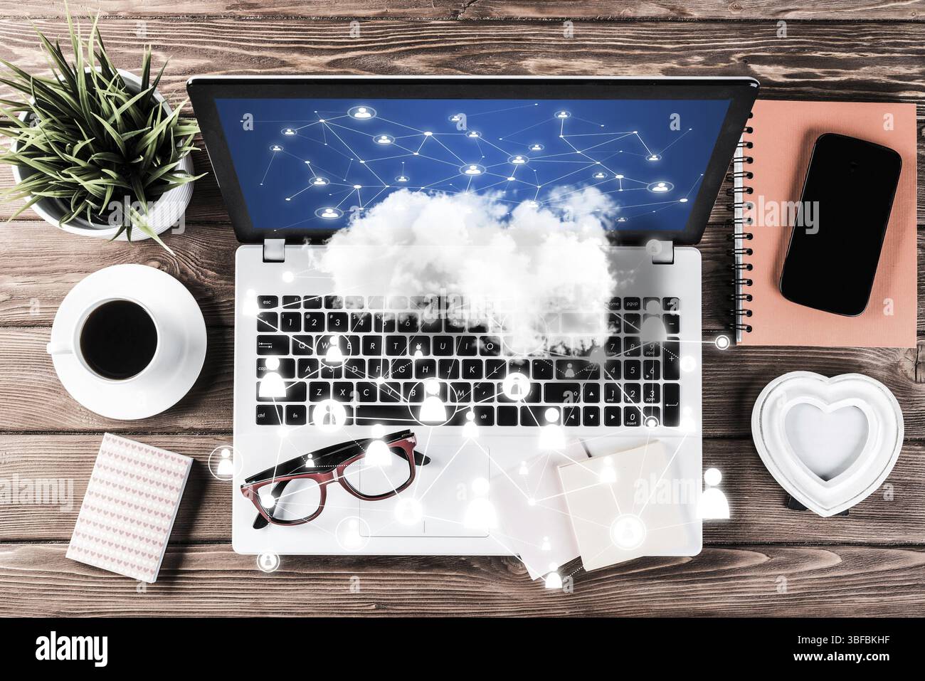 Vista dall'alto dell'ambiente di lavoro moderno, con oggetti per ufficio, connessioni di social network e cloud sopra come simbolo della vita lavorativa. Supporti misti Foto Stock