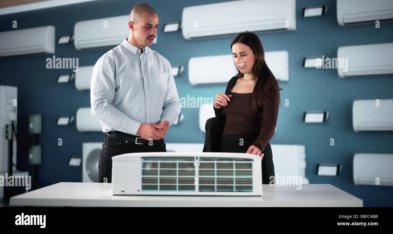 Una coppia felice incontra il venditore dell'aria condizionata presso l'hardware Store. Foto Stock