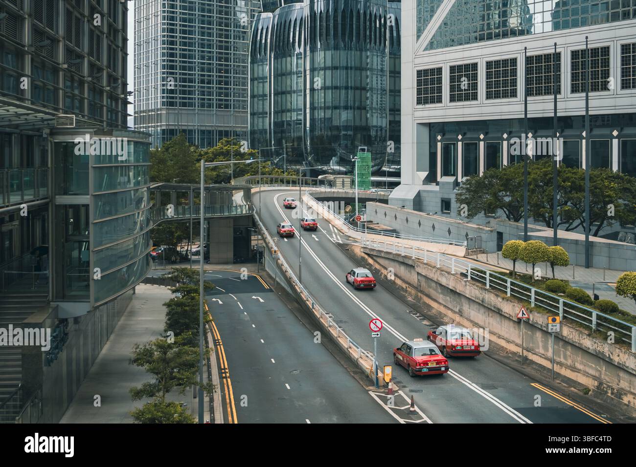 Linea di tradizionali veicoli taxi in stile Hong Kong nel centro cittadino di Hong Kong con edifici che la circondano Foto Stock