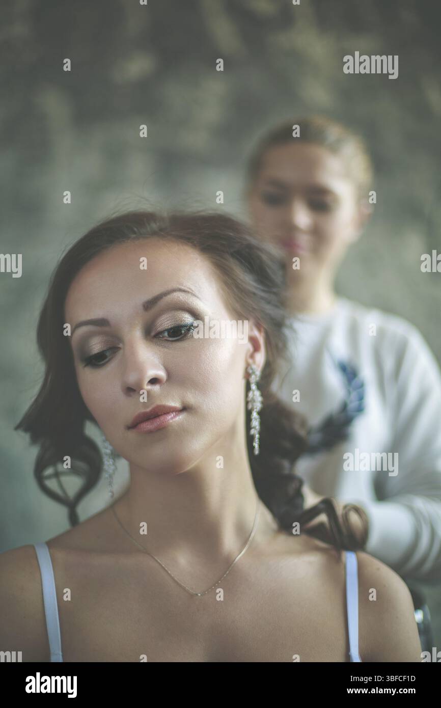 Hair stylist rende la sposa che il giorno del matrimonio Foto Stock