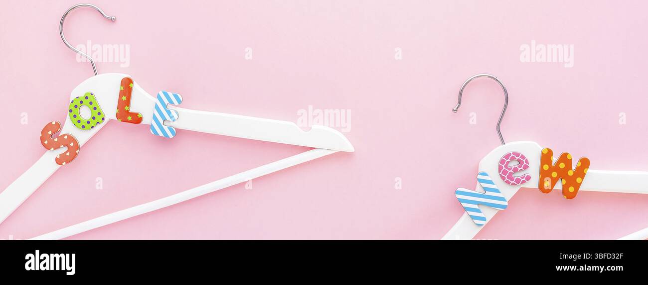 Creative vista superiore piatto bianco laici i portabiti in legno vendita testo rosa pastello sfondo spazio copia stile minimalista. Il modello femminile di moda social media s Foto Stock