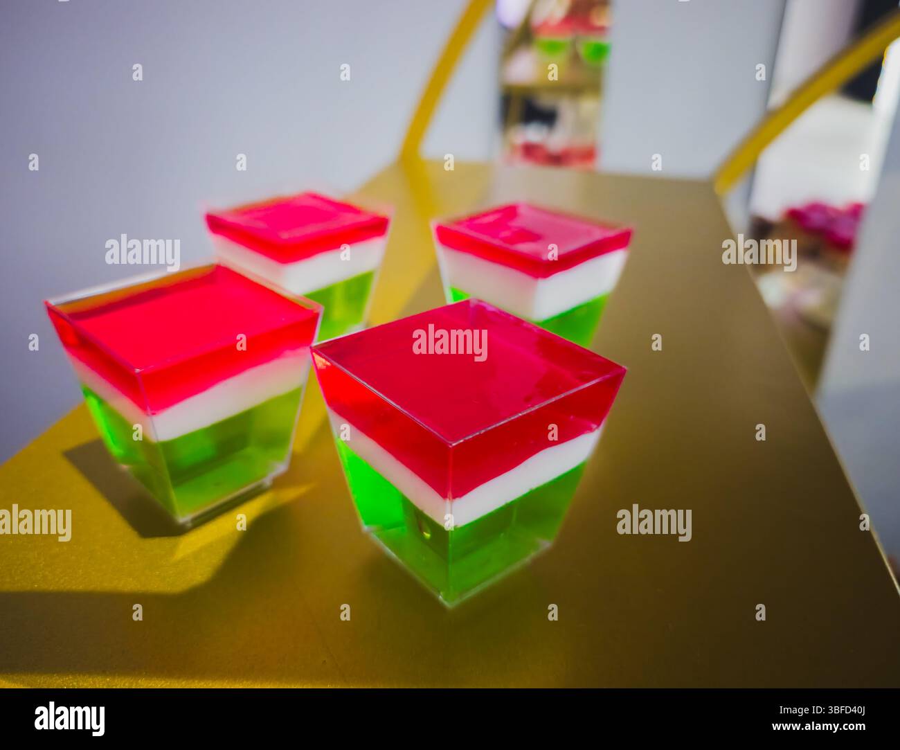 Dessert in gelatina a strati in rosso bianco e verde servito in tazze di plastica Foto Stock Dessert in gelatina a strati in rosso bianco e verde servito in tazze di plastica Foto Stock