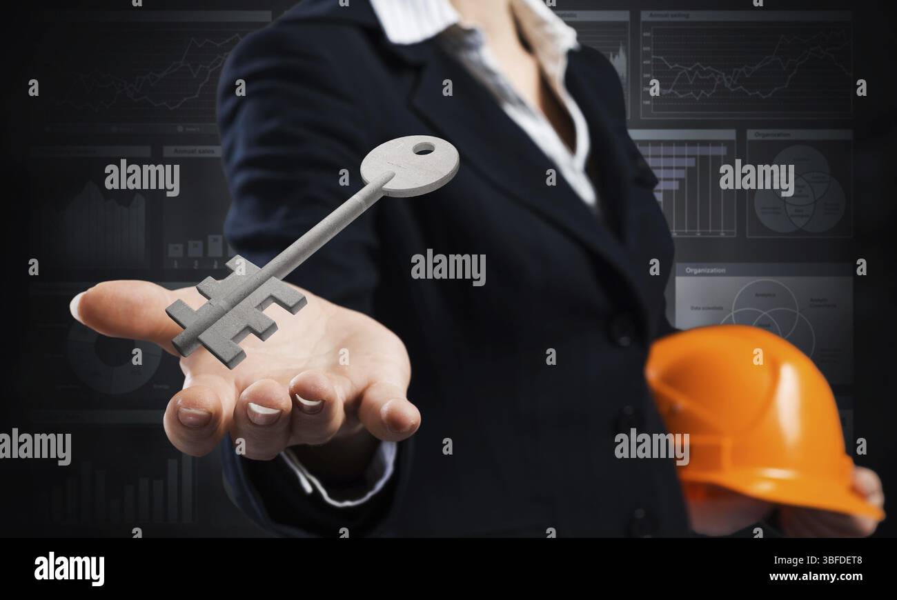 L'agente immobiliare tiene in mano la chiave 3d del palmo dalla serratura della casa. Agente immobiliare donna in costume da lavoro con casco di sicurezza. Progettazione e gestione dei progetti. Proprietà Foto Stock