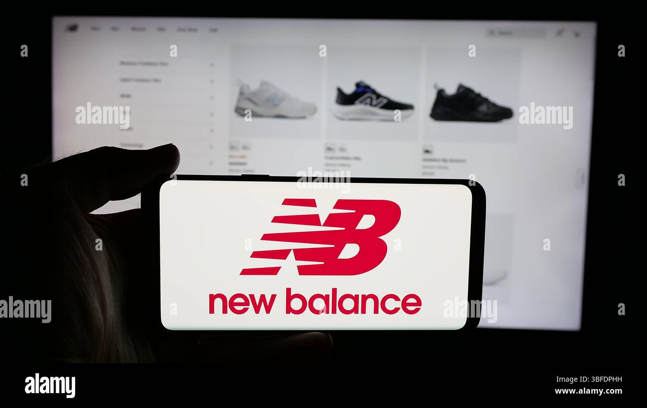 Germania. 7 maggio 2025. In questa immagine, una persona ha in mano un cellulare con il logo della società statunitense New Balance Athletics Inc. (NB) sullo schermo davanti alla pagina Web. Credito: SOPA Images Limited/Alamy Live News Foto Stock