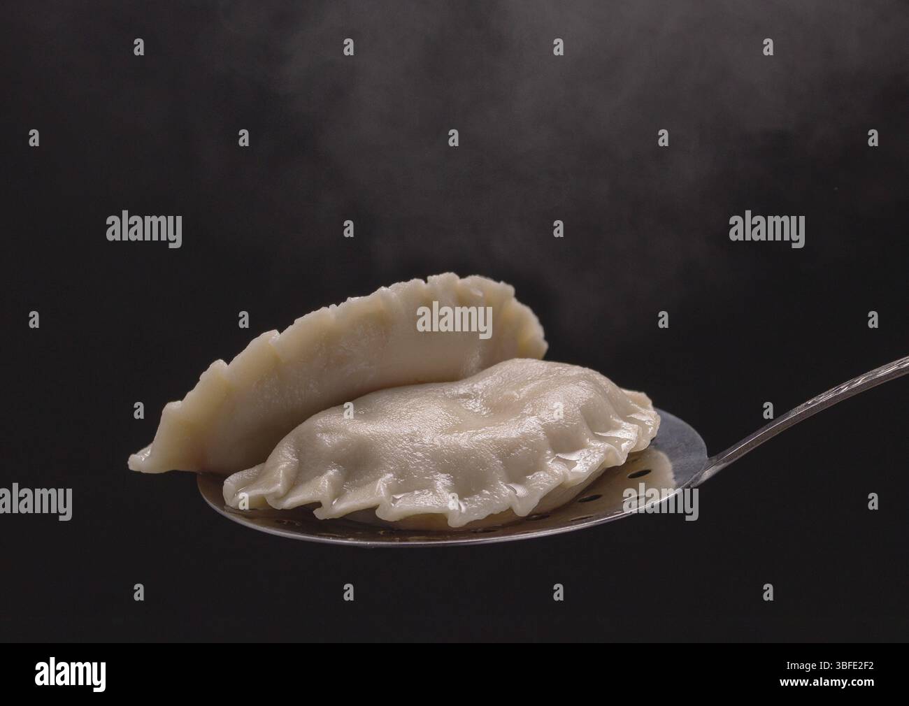 I gnocchi caldi fatti a mano giacciono su un cucchiaio scanalato Foto Stock