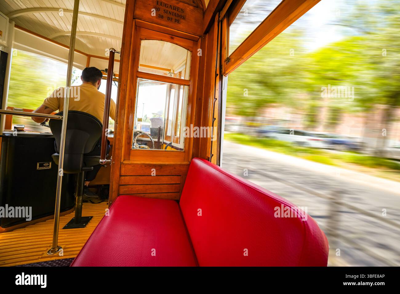 Autista ai comandi di uno storico tram 18E di Lisbona, che cattura gli interni vintage e il fascino senza tempo di uno dei trasporti più iconici del Portogallo. Foto Stock