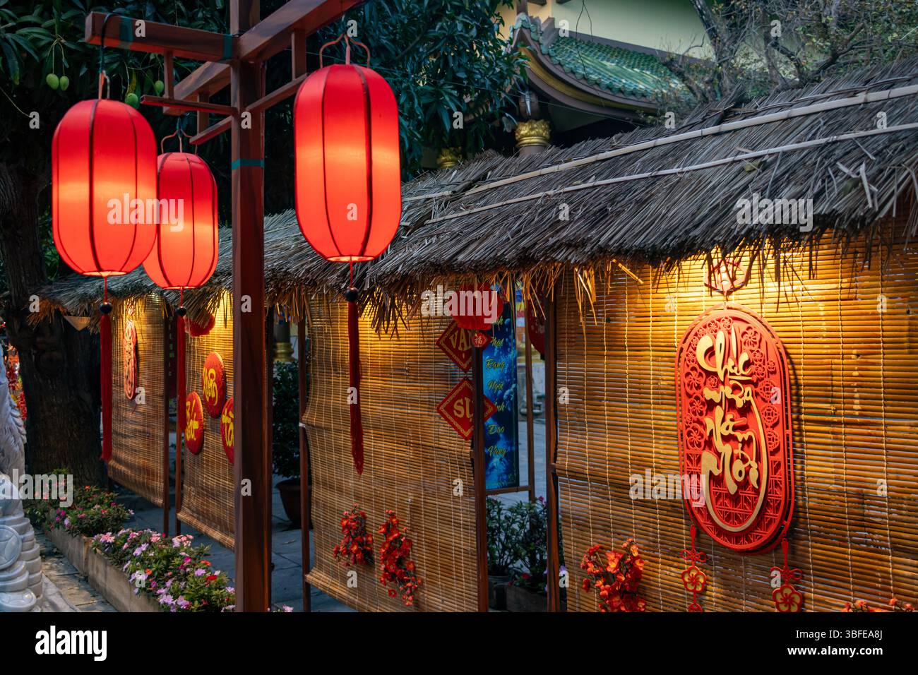 DANANG, VIETNAM, APR 24 2025, illuminata da lanterne rosse e pareti decorate creano un'atmosfera festosa al tempio buddista Foto Stock