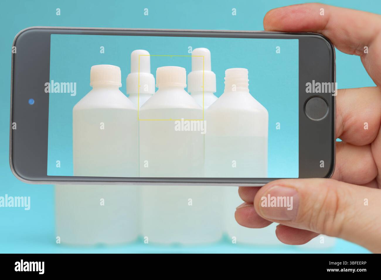 Fiale antisettiche sullo schermo dello smartphone. Liquido disinfettante in un flacone bianco. Farmaco terapeutico. Disinfezione contro coronavirus Foto Stock