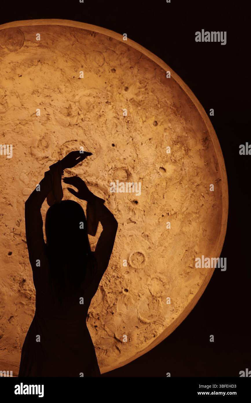 Una splendida silhouette di un ballerino ambientato su un'accattivante scena di sfondo illuminato dalla luna Foto Stock