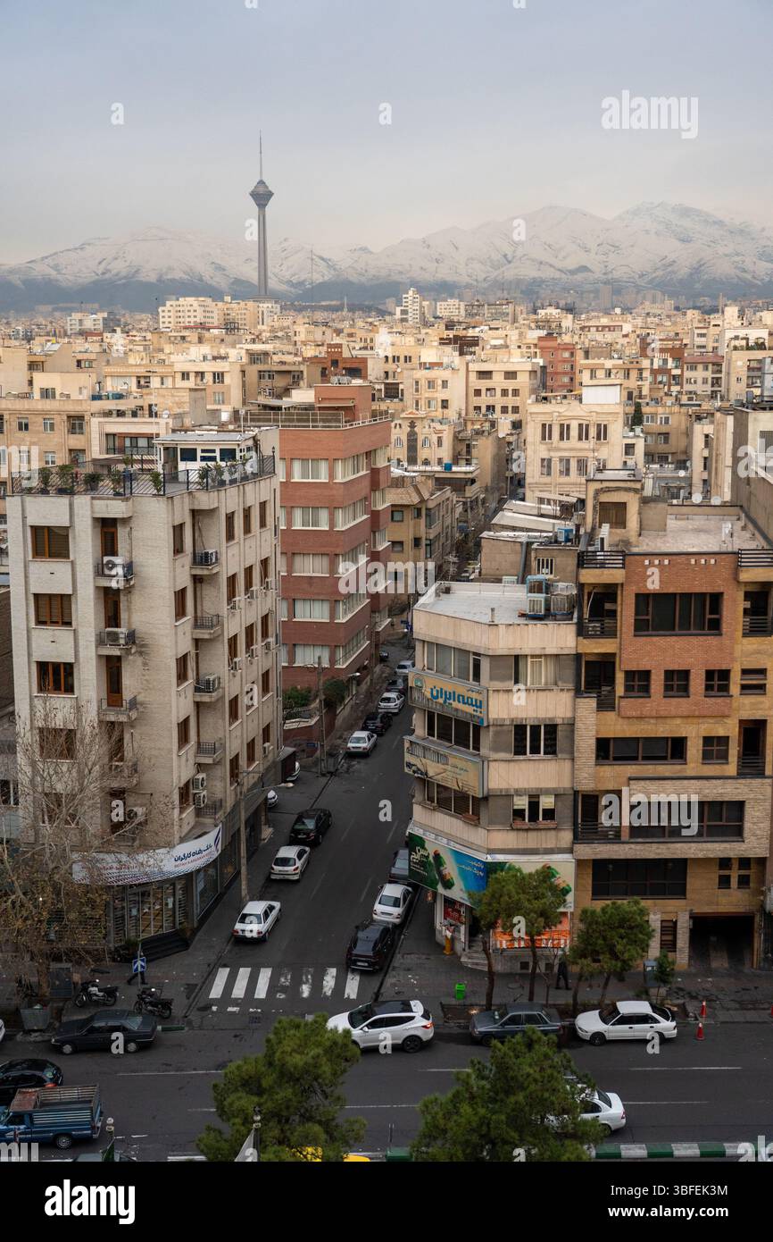 Teheran, Iran - 12 novembre 2023: Edifici residenziali e Milad Tower con montagne innevate di Alborz sullo sfondo Foto Stock