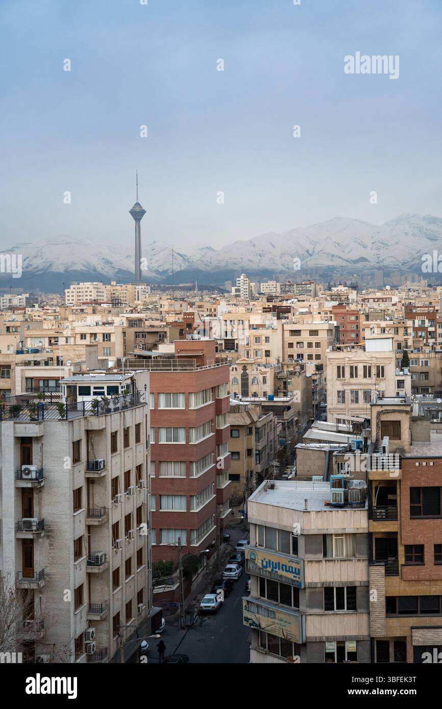 Teheran, Iran - 12 novembre 2023: Paesaggio urbano con la Torre Milad che si innalza sopra gli appartamenti della città Foto Stock