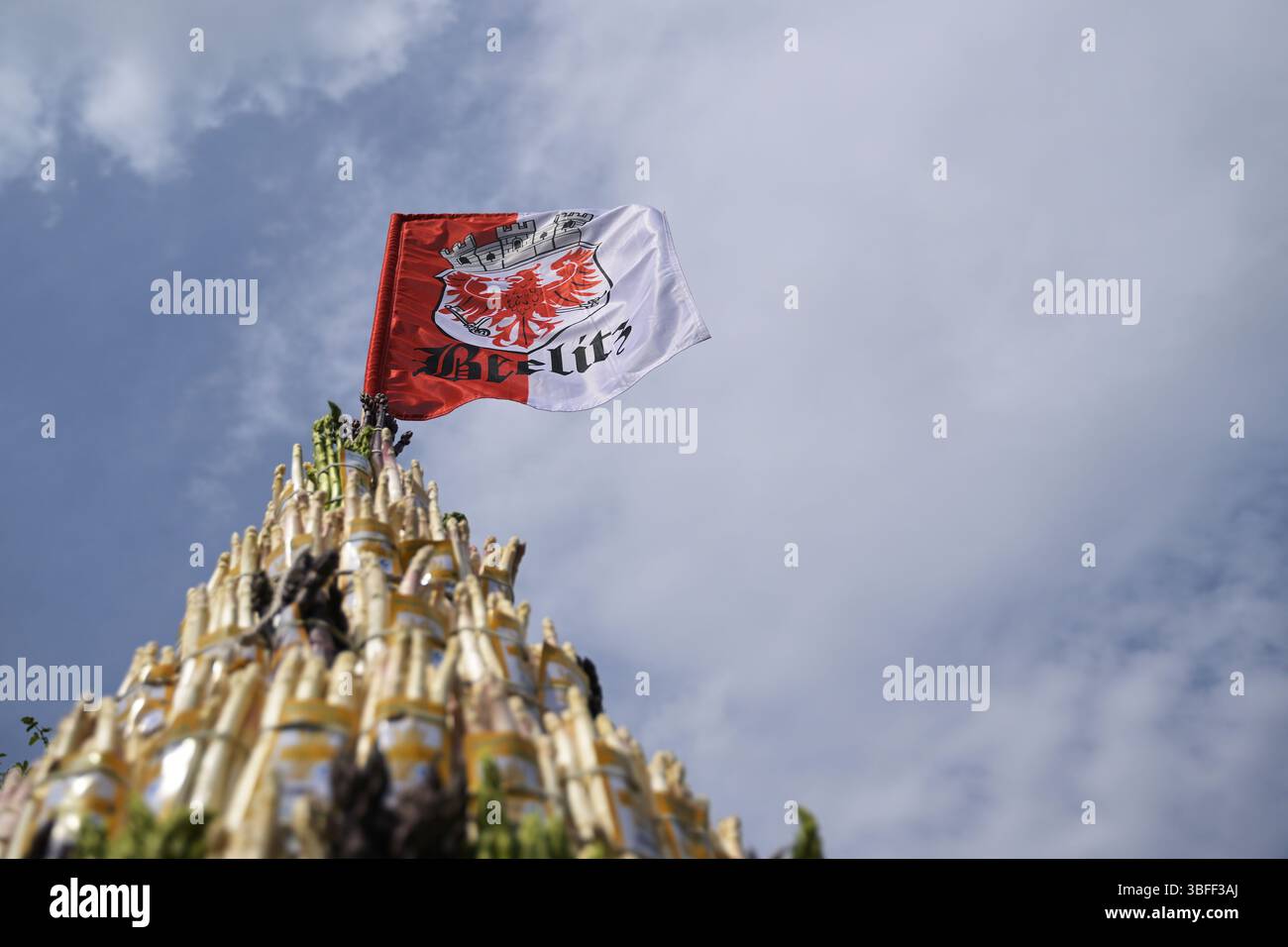 Beelitz, Germania. 1 giugno 2025. Una piramide di asparagi fatta di asparagi bianchi, neri e verdi viene presentata durante la sfilata al Beelitz Asparagus Festival. La bandiera di Beelitz con lo stemma della città vola in cima alla piramide. L'evento è il momento culminante delle celebrazioni di più giorni nella città che cresce gli asparagi. Credito: Michael Bahlo/dpa/Alamy Live News Foto Stock