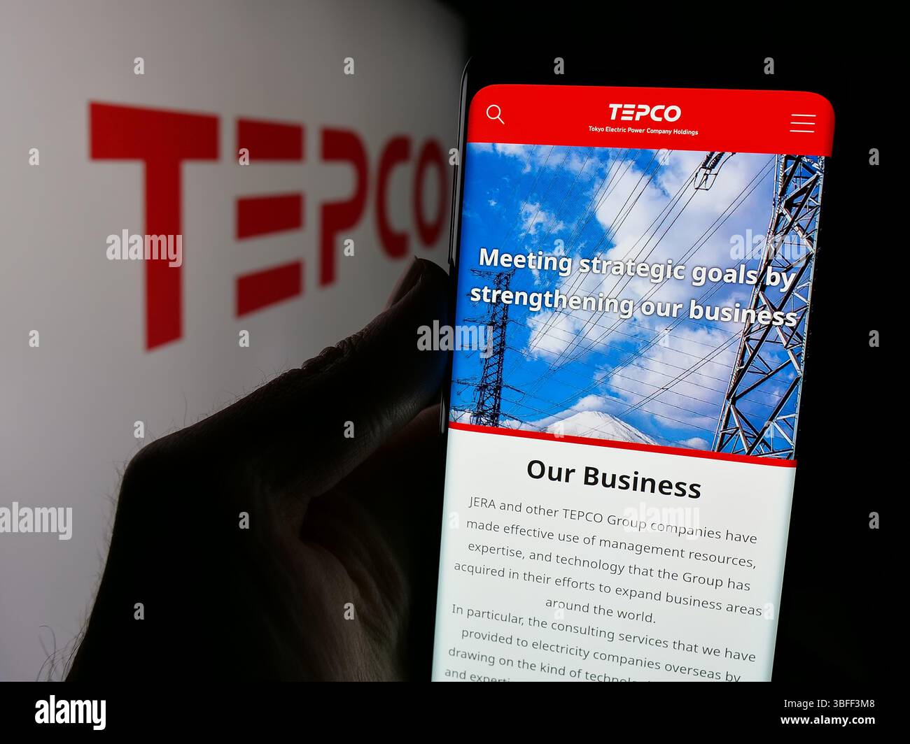 Stoccarda, Germania - 01-22-2025: Persona che detiene un telefono cellulare con il sito web della società Tokyo Electric Power Company (TEPCO) sullo schermo con il logo. Foto Stock