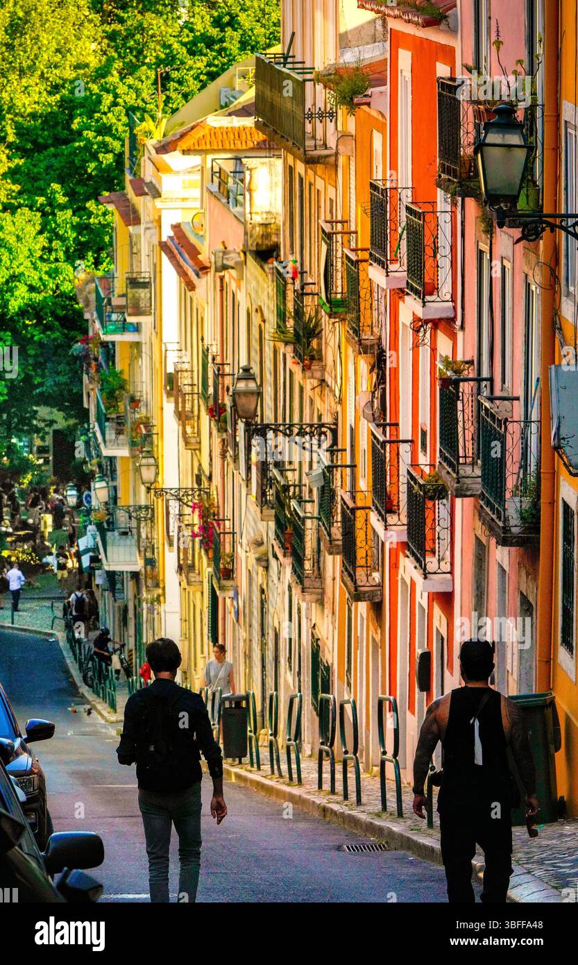 Facciate colorate e balconi in ferro battuto in una ripida strada del quartiere Bairro alto di Lisbona. Pomeriggio di sole nella capitale del Portogallo. Foto Stock
