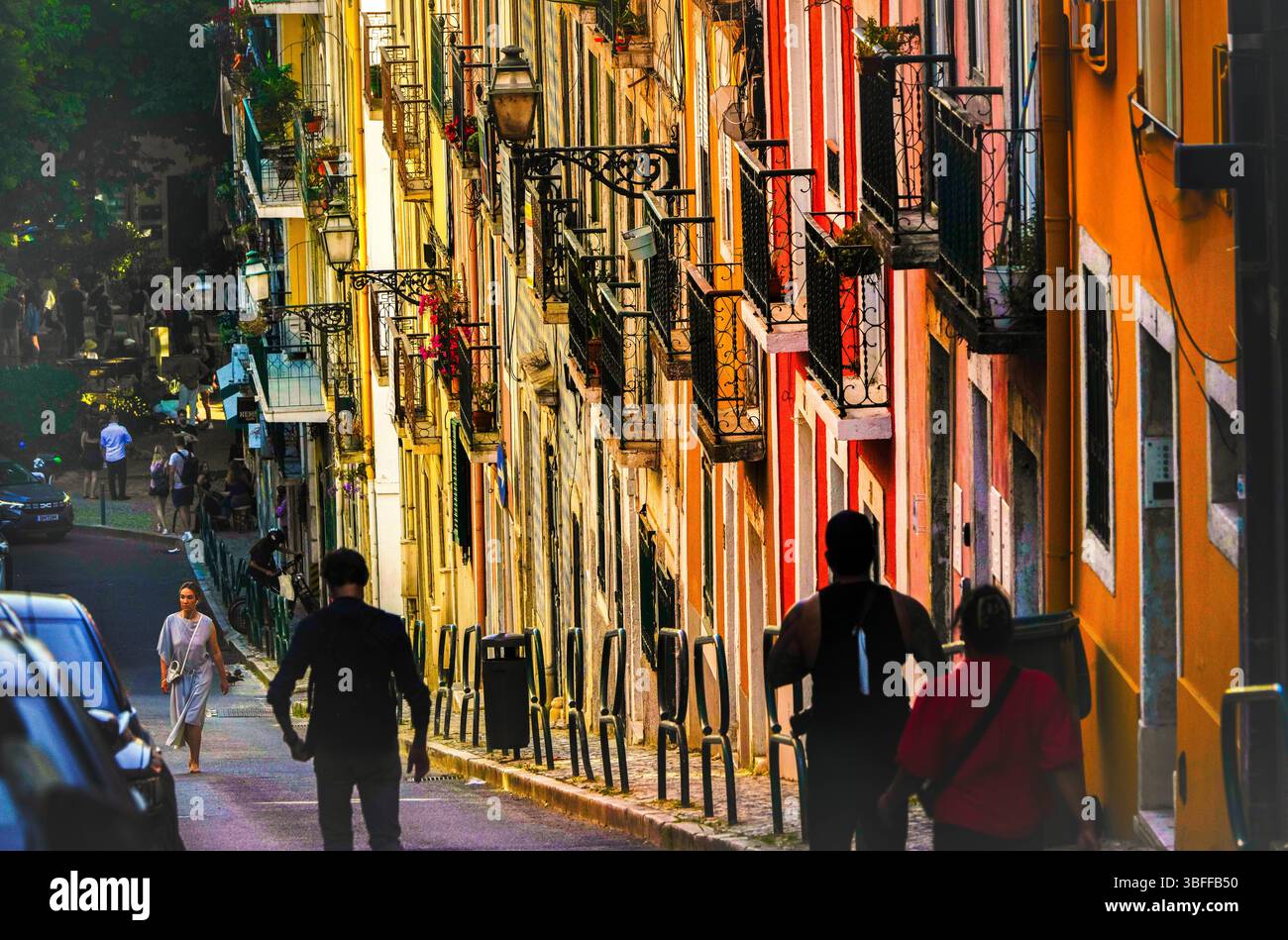 Facciate colorate e balconi in ferro battuto in una ripida strada del quartiere Bairro alto di Lisbona. Pomeriggio di sole nella capitale del Portogallo. Foto Stock