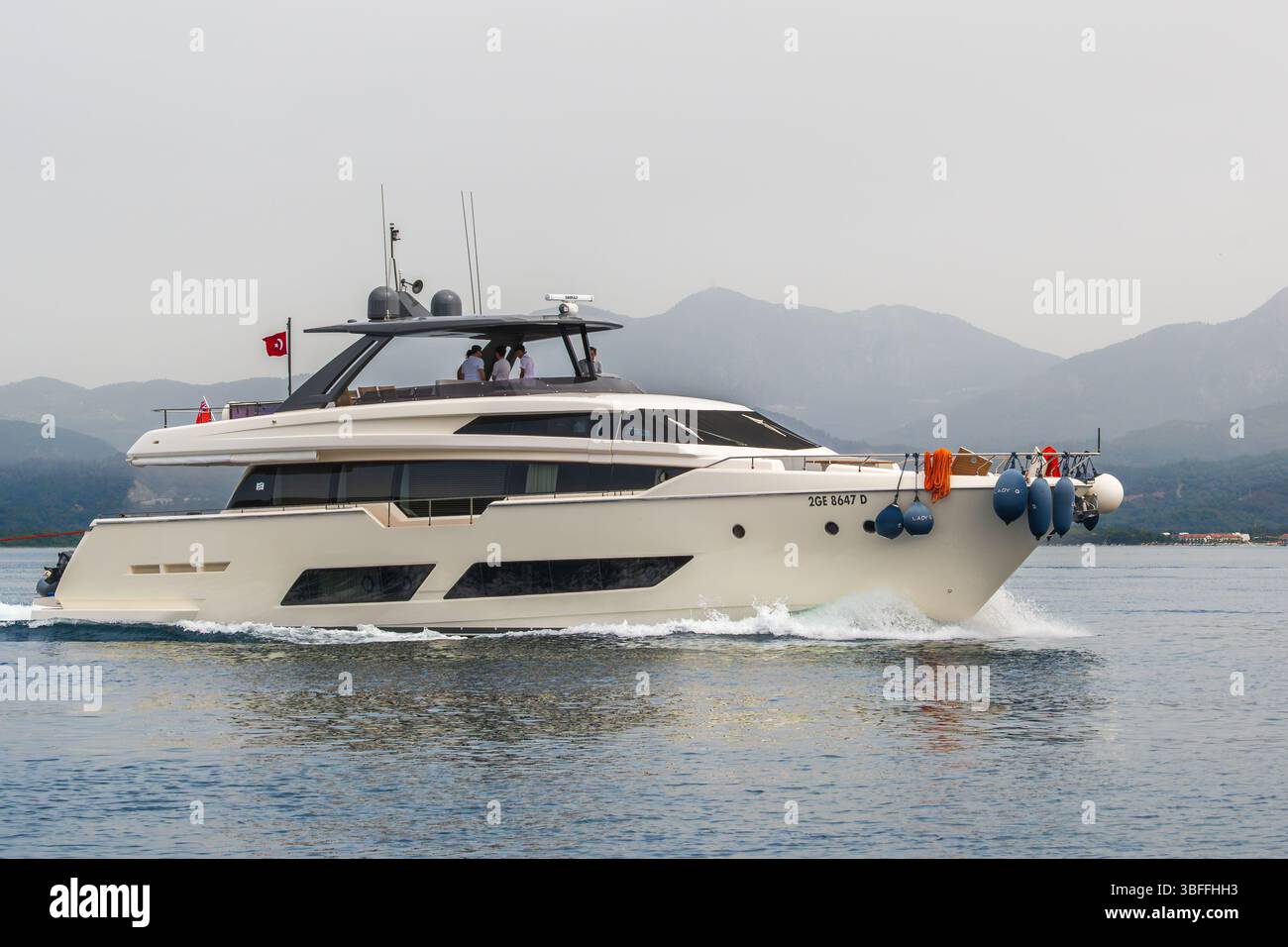 Con una bandiera turca che sventola, questa impressionante nave si muove attraverso l'acqua. Rappresenta un viaggio di lusso e un esclusivo super yacht marino Foto Stock