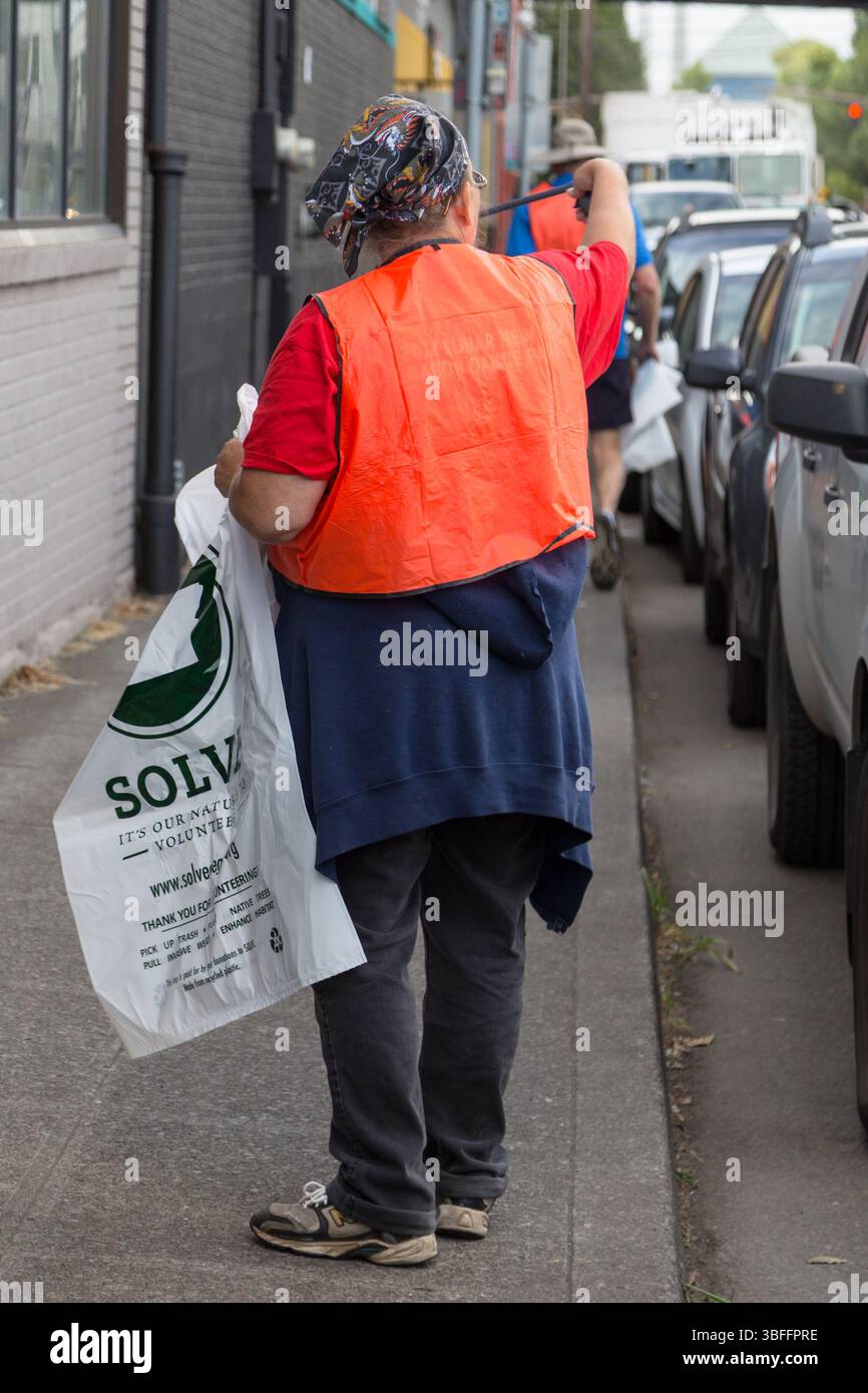 Portland, Oregon - 17 agosto 2017: Un volontario con SOLVE raccoglie rifiuti per migliorare l'habitat e mantenere pulita la fattoria di marijuana. Foto Stock