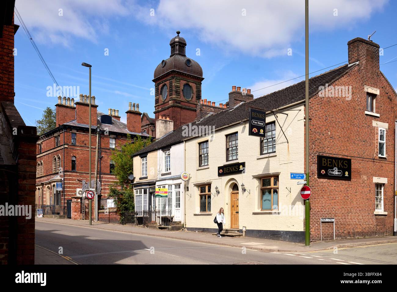 Leek Market Town nello Staffordshire, pub Benks con Leek Library parte del Leek e il Buxton College torreggiante alle spalle Foto Stock