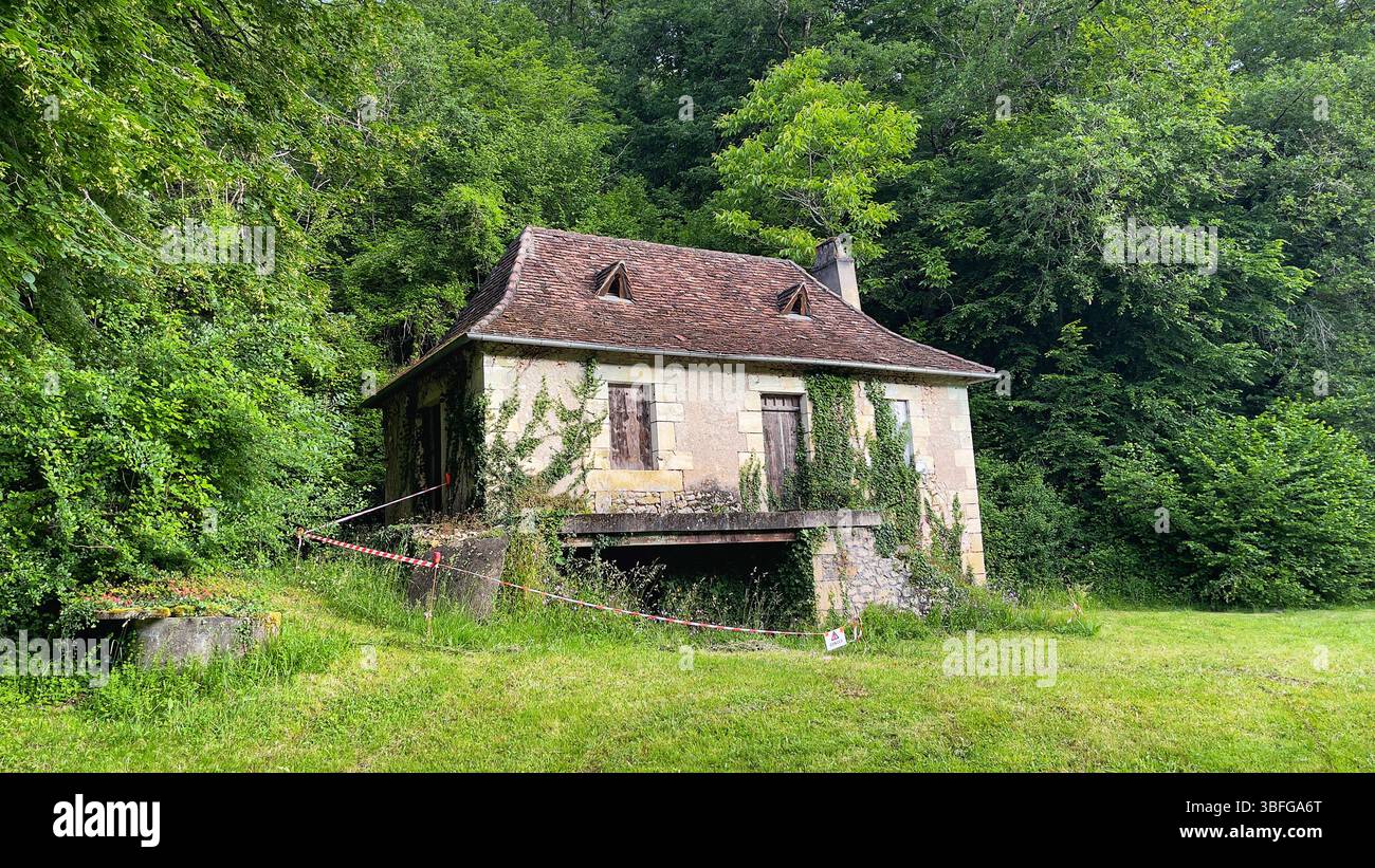 Una casa francese abbandonata si erge in tranquilla solitudine, con le sue pietre intemprate e la vegetazione che invade, sussurrando storie di un passato dimenticato Foto Stock