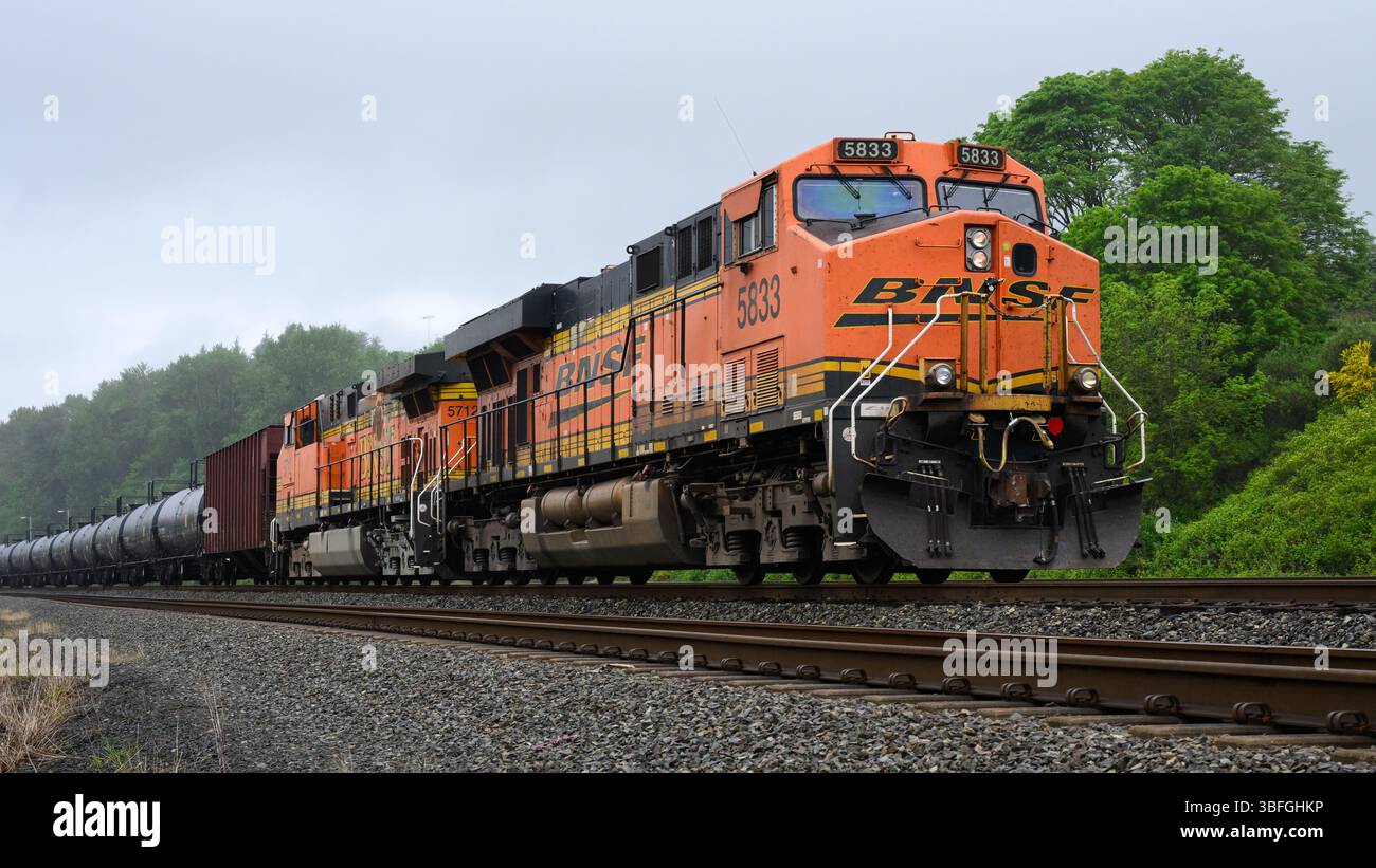 Seattle - 17 maggio 2025; BNSF GE ES44AC su bagnato giorno piovoso per il trasporto di merci in treno petrolifero Foto Stock