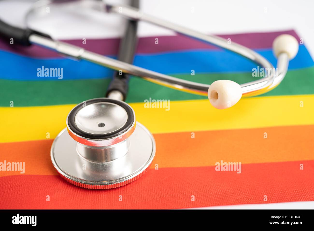 Stetoscopio su sfondo bandiera arcobaleno, simbolo del mese dell'orgoglio LGBT festeggia ogni anno nel mese di giugno sociale, simbolo di gay, lesbiche, bisessuali, transgender, hu Foto Stock