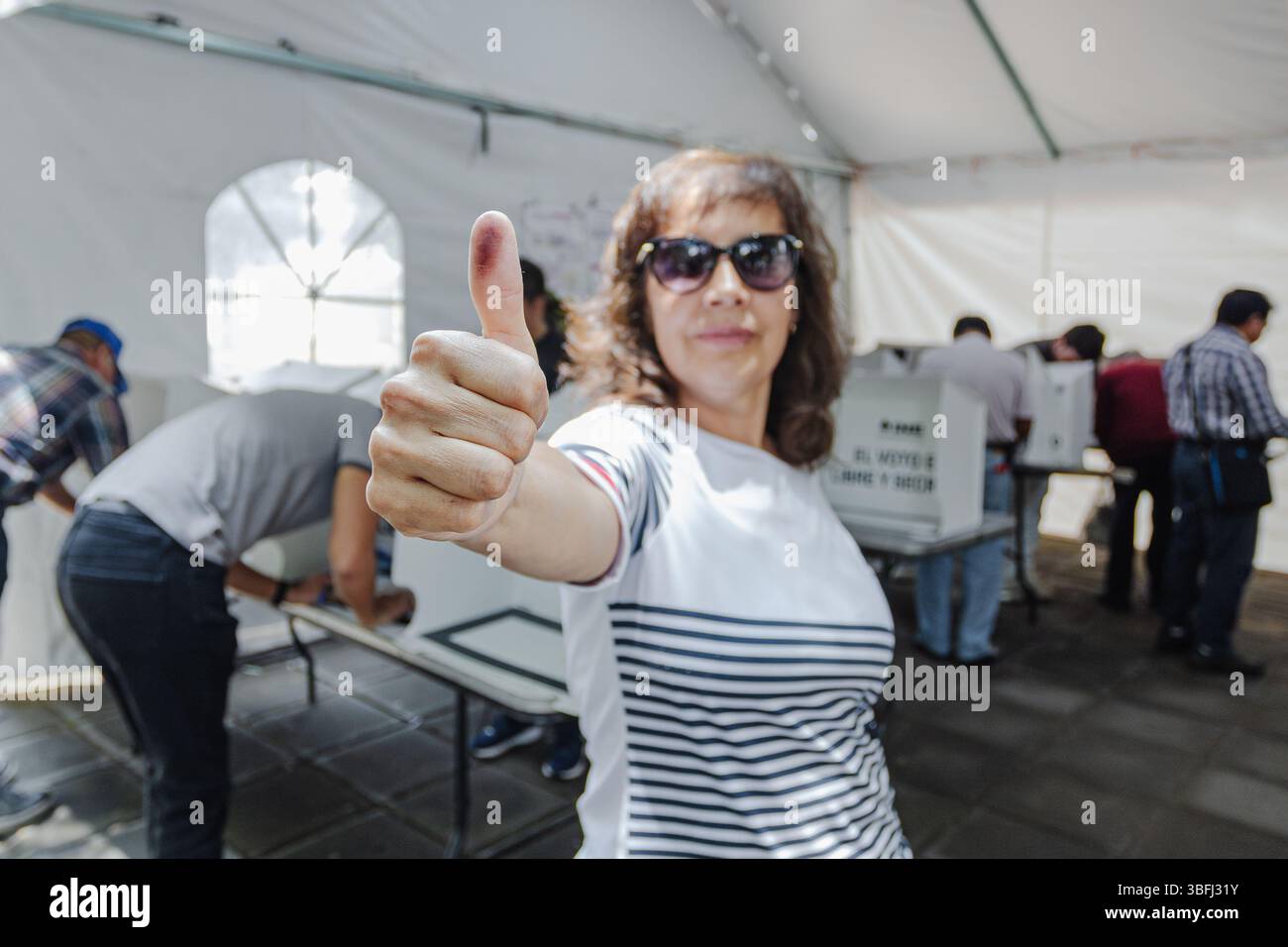 I cittadini alzano con orgoglio il pollice per indicare la loro partecipazione alle prime elezioni giudiziarie del paese. Foto Stock