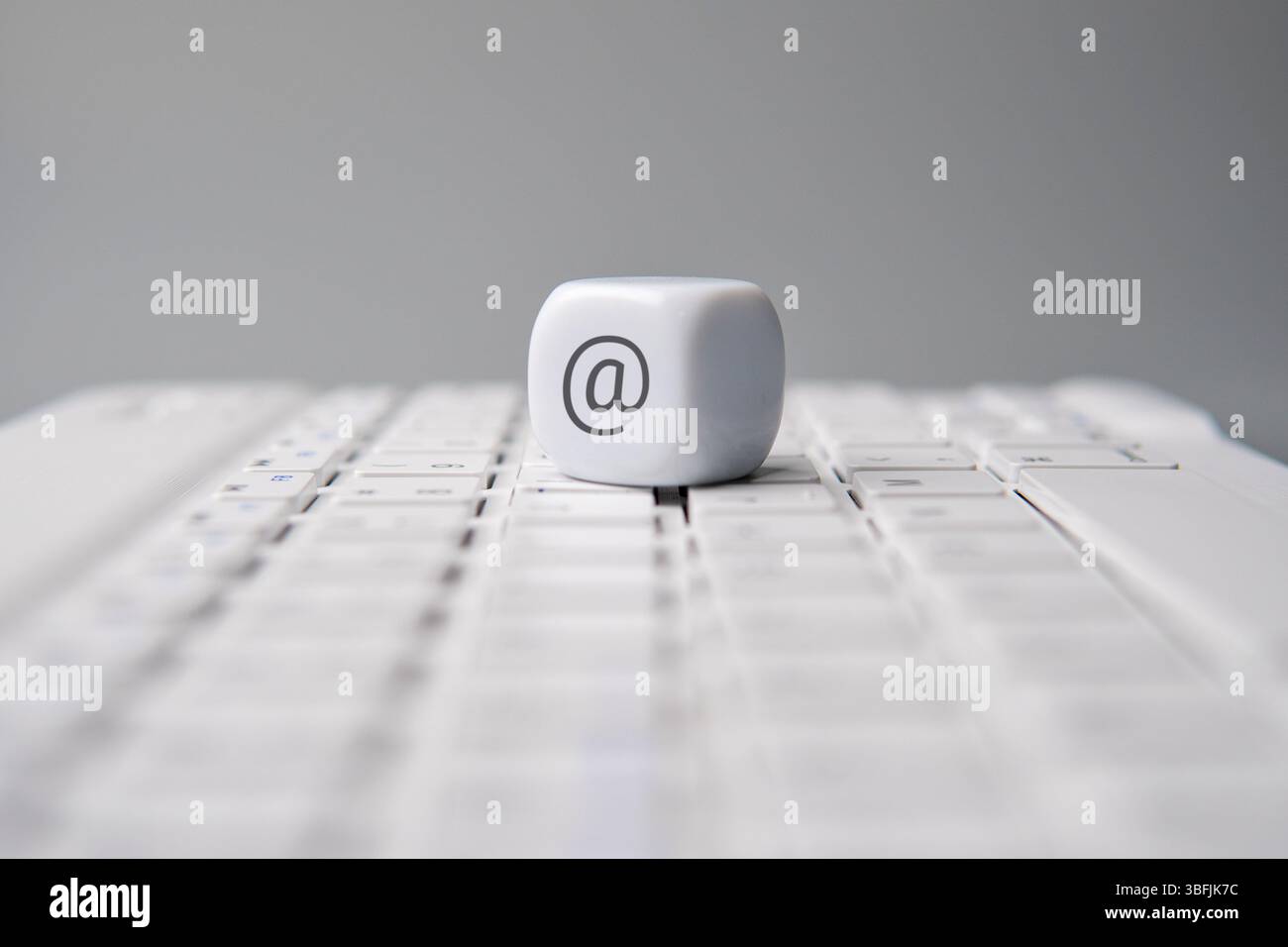 Cubo con il simbolo AT o AT sulla tastiera di un notebook. E-mail, Internet, concetto di comunicazione. Foto Stock