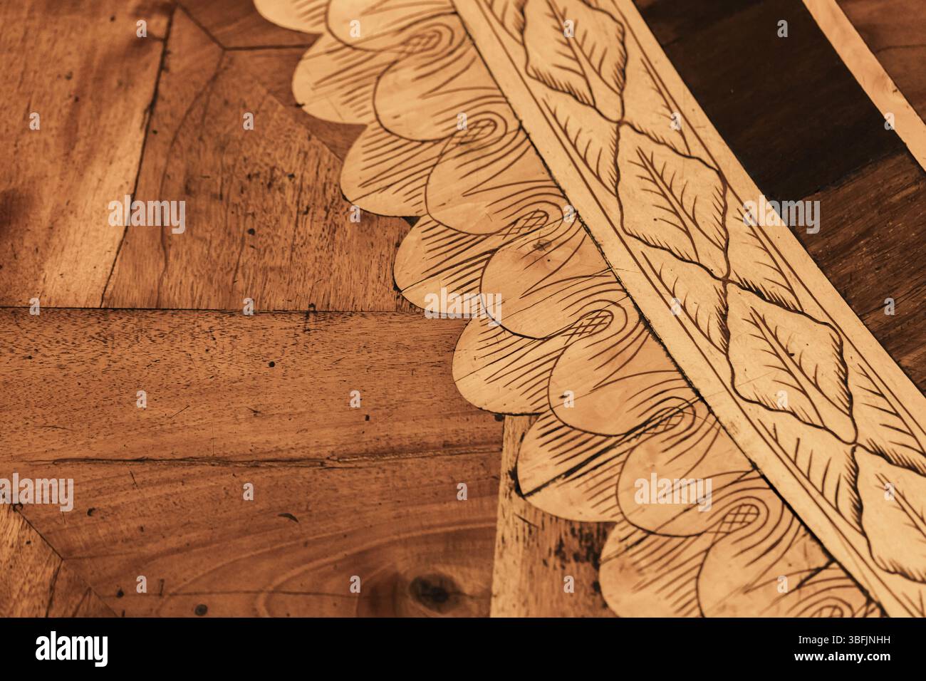 Pannelli in parquet di legno con intricate incisioni di foglie e vortici, che esprimono l'artigianalità e l'estetica naturale. Rappresentazione perfetta o Foto Stock