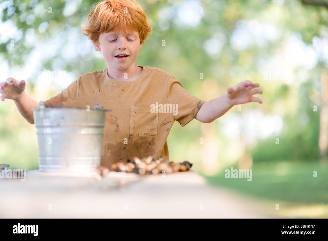 Bambino felice che guarda la sua collezione naturale del giorno Foto Stock