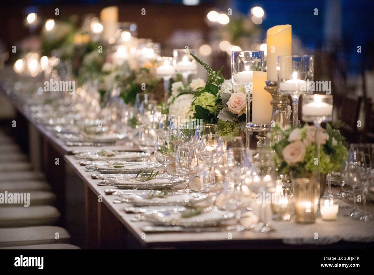 Romantico tavolo per banchetti a lume di candela con pezzi centrali floreali Foto Stock