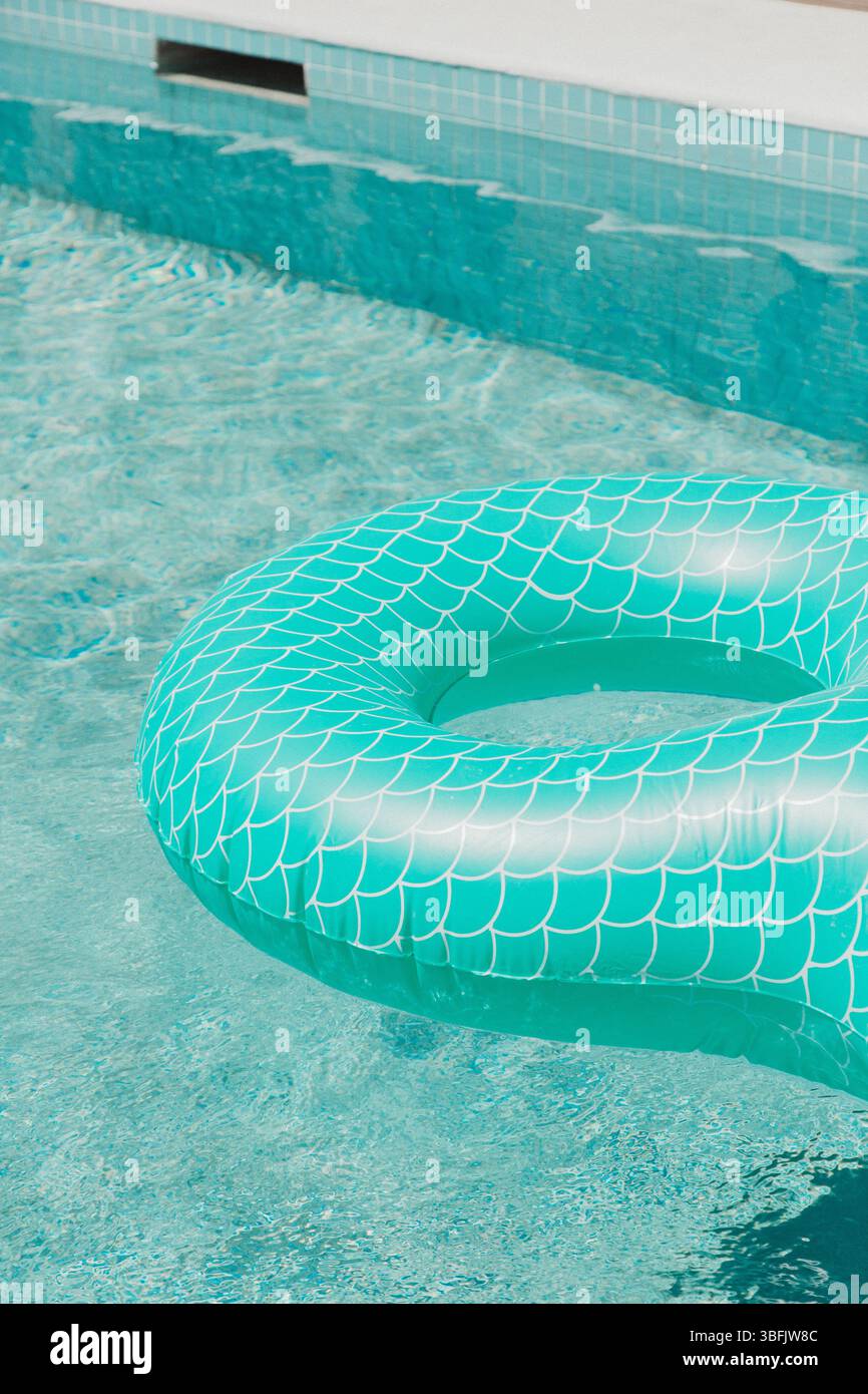 Anello galleggiante in scala sirena color tè in una piscina limpida Foto Stock