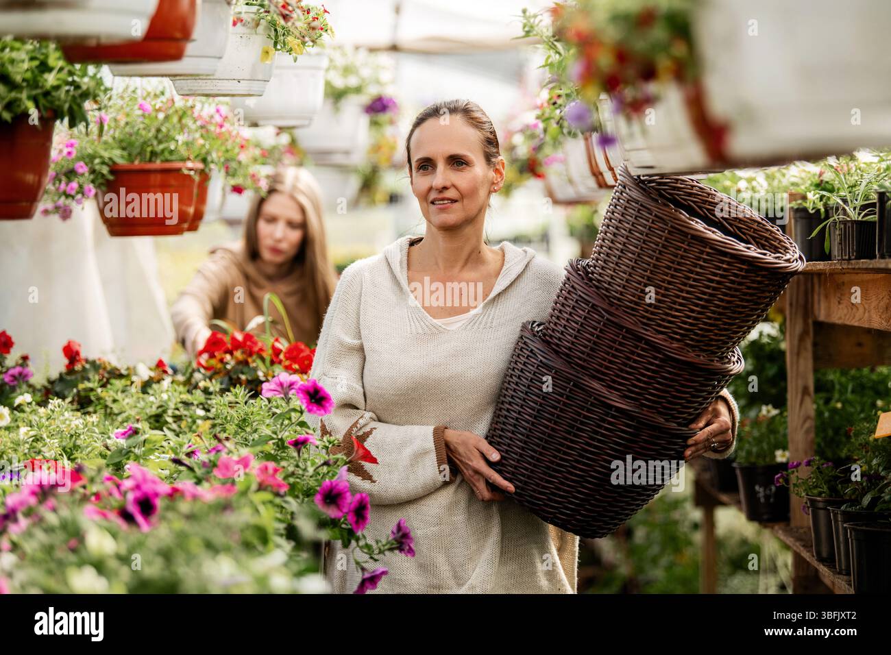 Donna che acquista cesti in un negozio di fiori Foto Stock