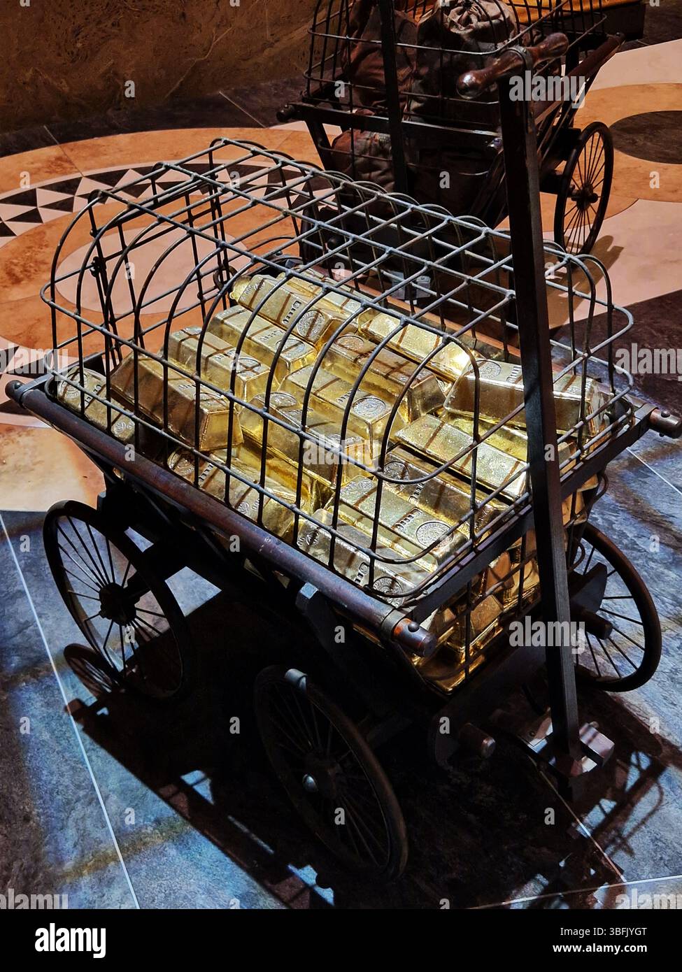 Barre dorate fissate in gabbia metallica su un display di carrello d'epoca. Londra, Regno Unito Foto Stock