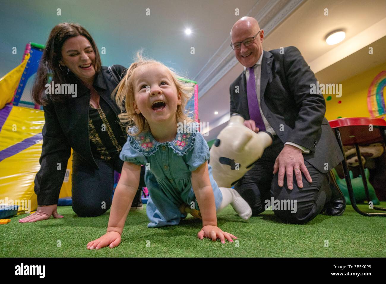 Il leader del SNP e primo ministro John Swinney e il candidato del SNP Katy Loudon con Grace Ure, di 2 anni, durante una visita alla Juniors Charity a Hamilton, Lanarkshire, mentre si trovava sulla pista della campagna elettorale in vista delle prossime elezioni suppletive di Hamilton, Larkhall e Stonehouse di giovedì. Data foto: Lunedì 2 giugno 2025. Foto Stock