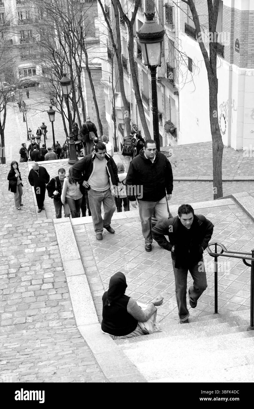 Parigi 2006 persone camminano accanto a una donna che implorava sui gradini di Rue Foyatier a Montmartre, Parigi. Foto Stock