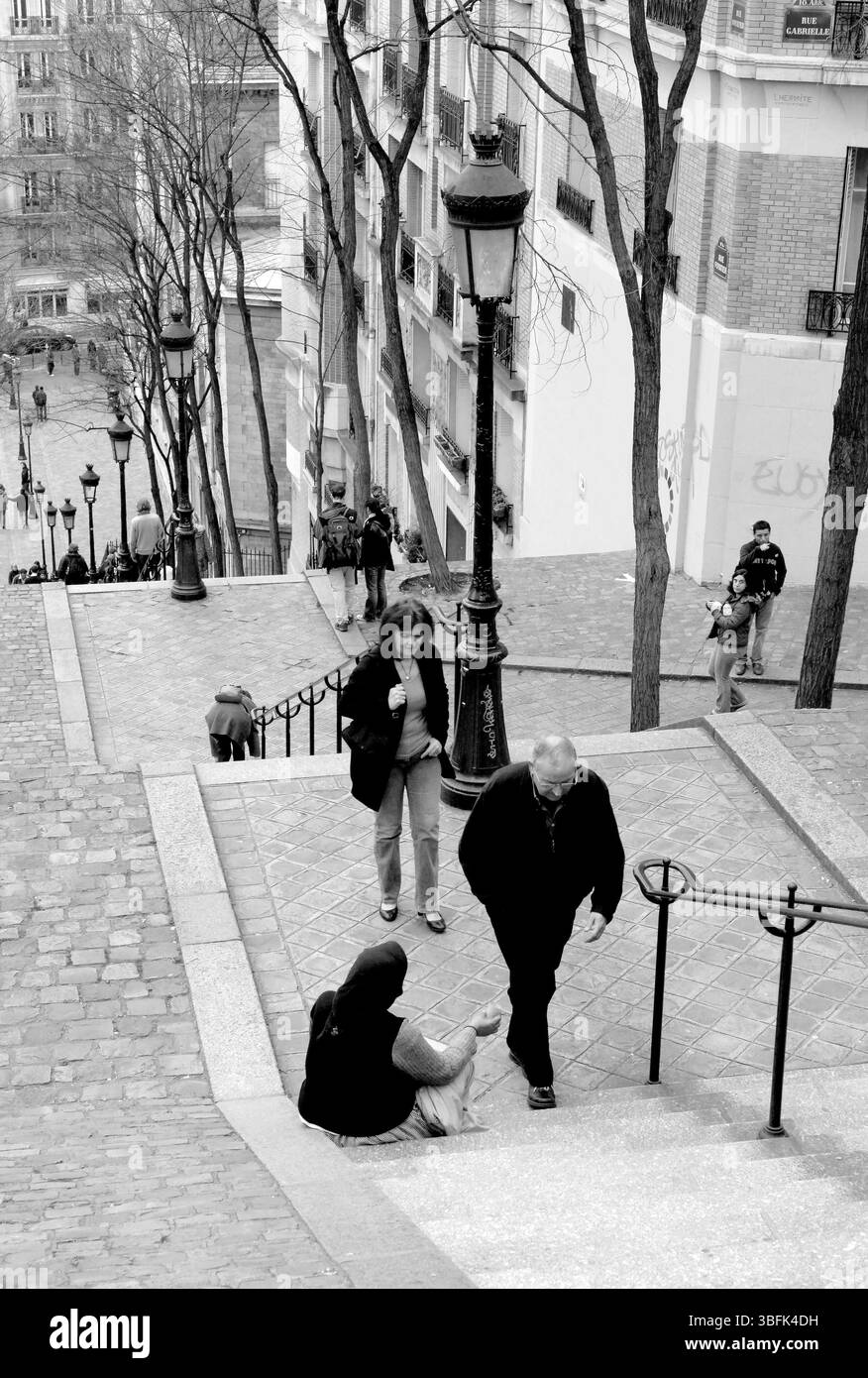 Parigi 2006 persone camminano accanto a una donna che implorava sui gradini di Rue Foyatier a Montmartre, Parigi. Foto Stock